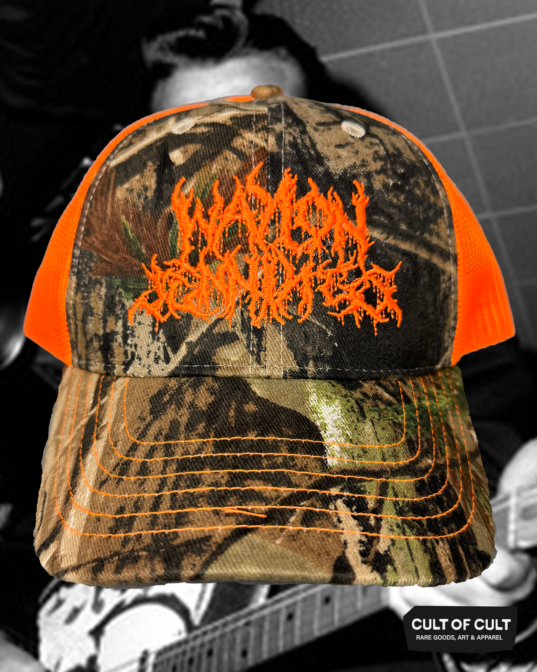 the front of the orange and camo Waylon Jennings trucker hat