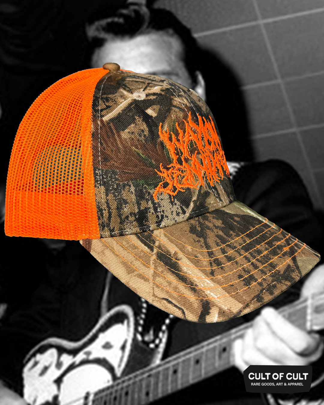 a side view of the orange and camo Waylon Jennings trucker hat