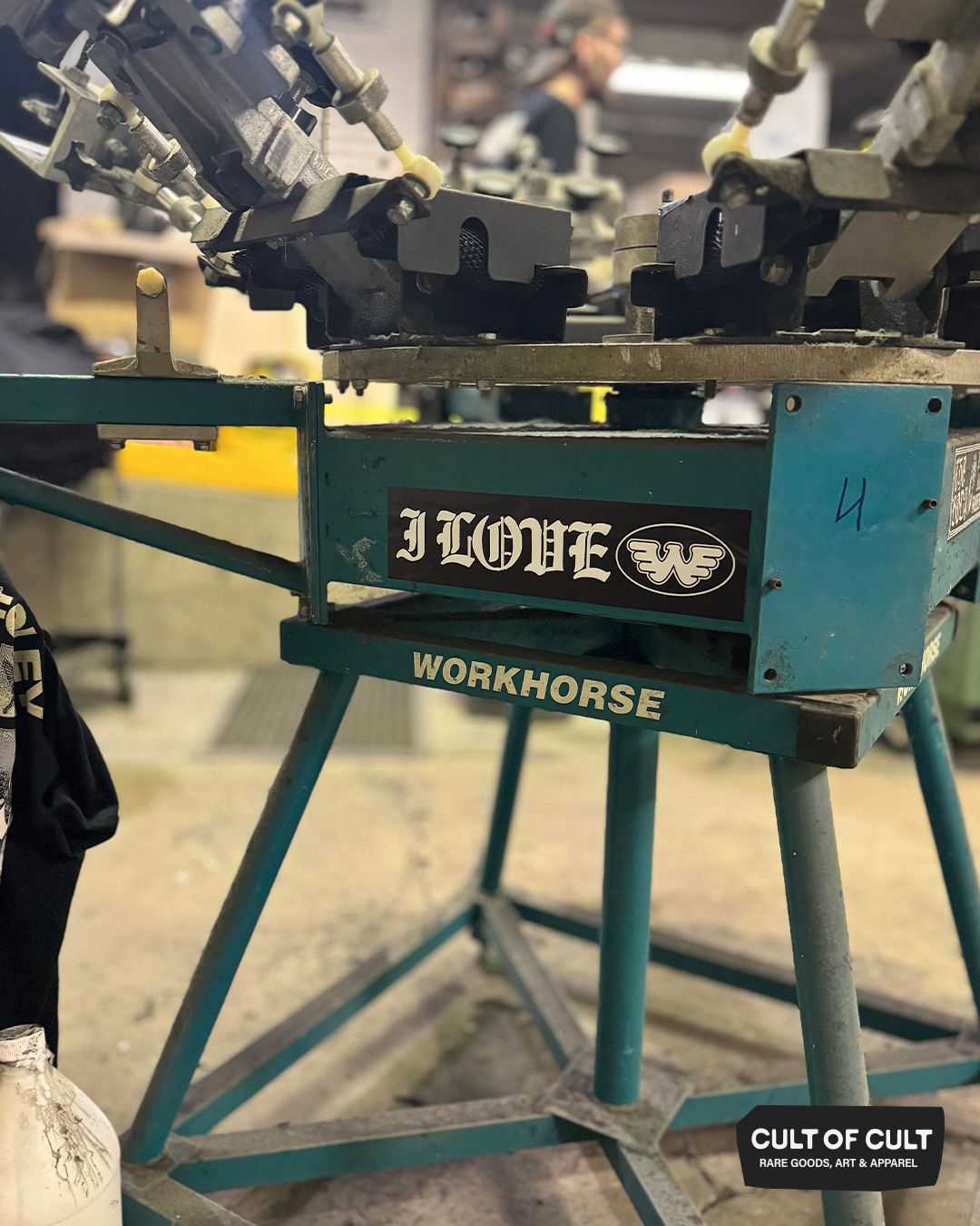 The I Love Waylon bumper sticker shown on a screen printing press