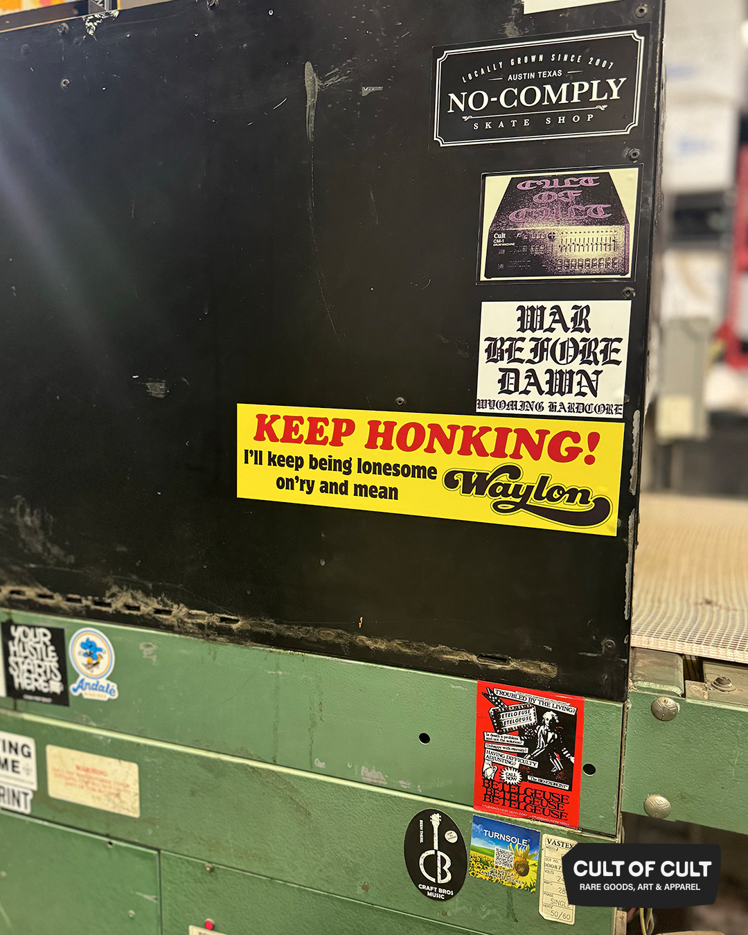 The Keep Honking Waylon Jennings bumper sticker on a shirt dryer around other stickers